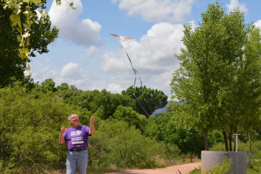 Man flies kite while walking outdoors