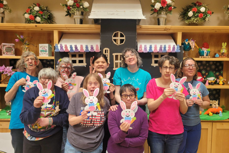 The woman ranchers show off their easter craft project lead by their caregiver in their group home.